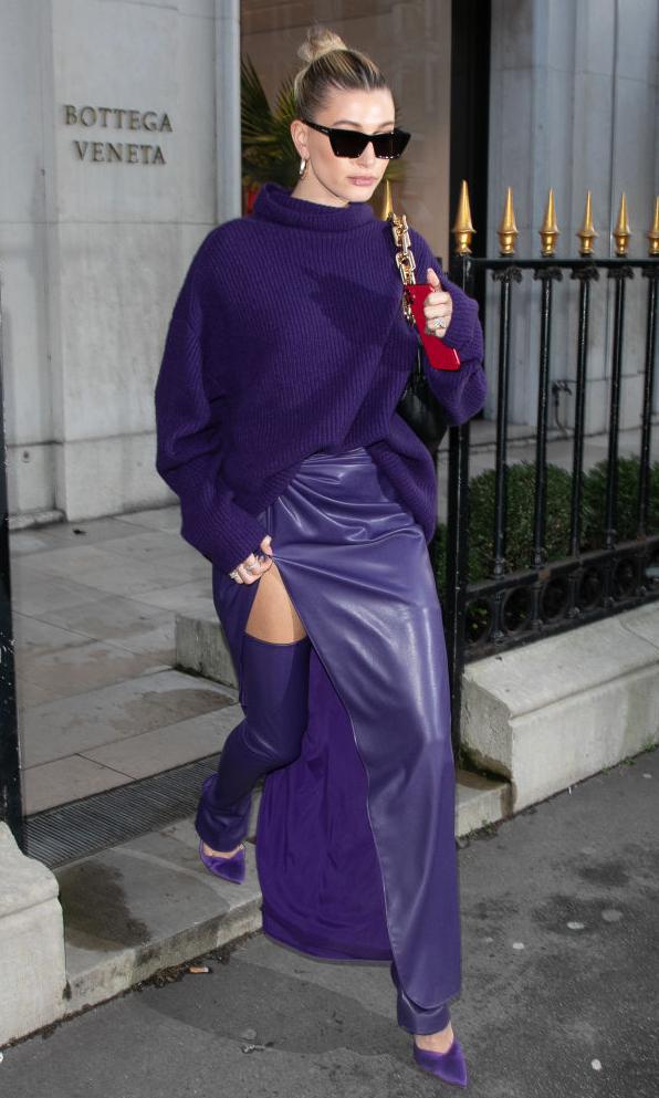 hailey baldwin con look de falda de cuero purpura y tights a juego