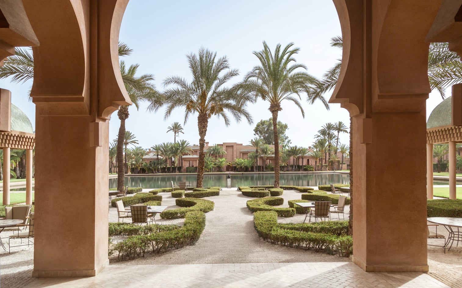 Our Work 1 Amanjena, Marrakech — gardens and reflecting pool framed by terracotta arches